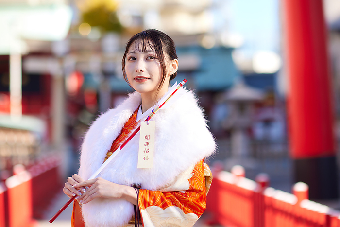Japanese woman in furisode kimono holding a hakama arrow