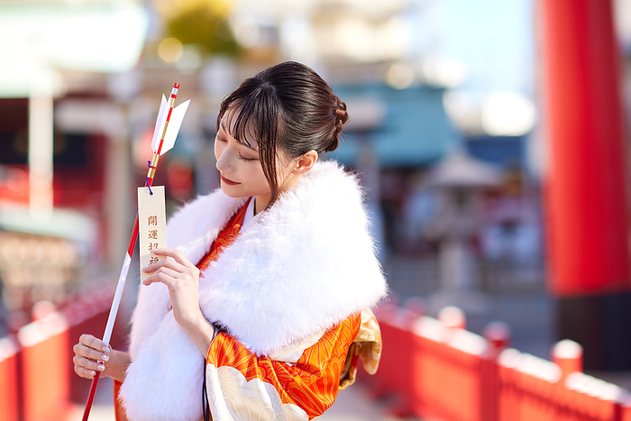 Japanese woman in furisode kimono holding a hakama arrow