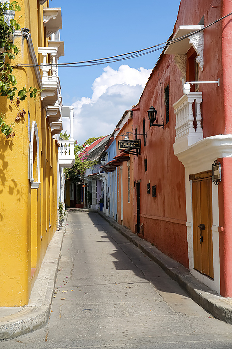 View to a narrow street framed by yellow and pink houses on a sunny day in Old Town, Cartagena, Colo View to a narrow street framed by yellow and pink houses on a sunny day in Old Town, Cartagena, Colo, by Zoonar Uwe Bergwitz