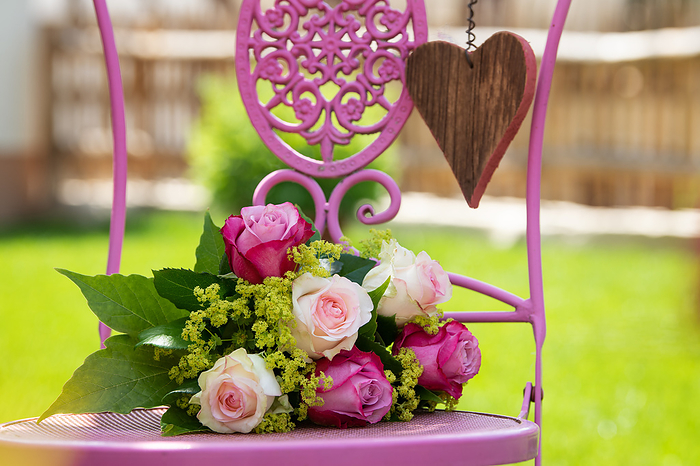 Loving bouquet of pink roses on a pink garden chair Loving bouquet of pink roses on a pink garden chair, by Zoonar Judith Kiener