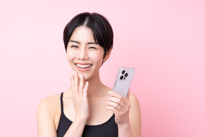 Young Japanese woman holding a cell phone (People)