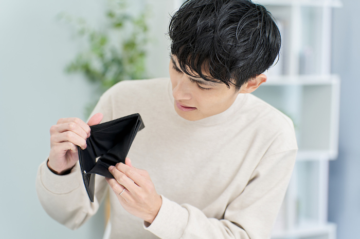 Japanese man holding wallet with no money in it.