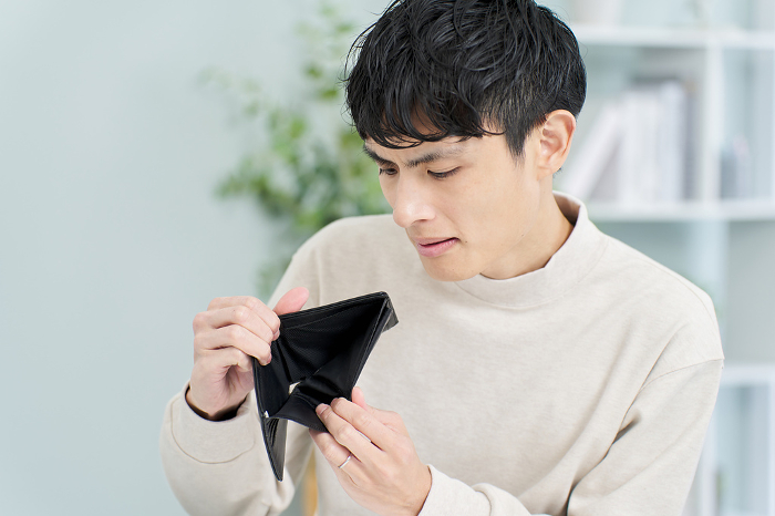 Japanese man holding wallet with no money in it.