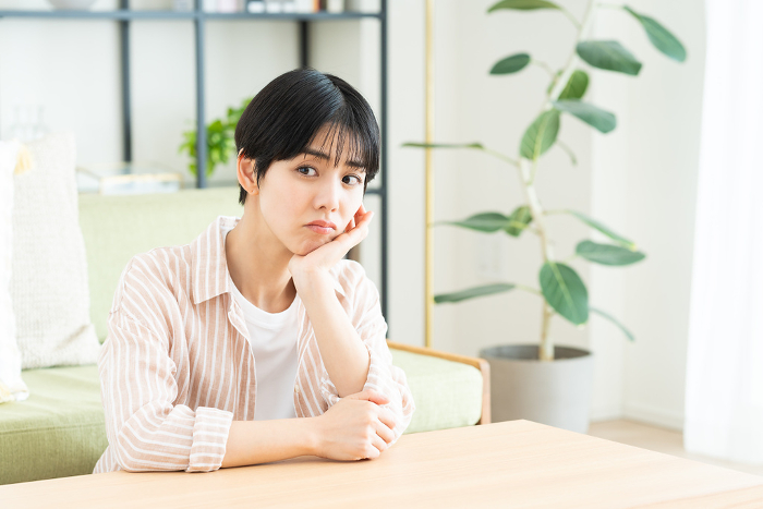 A young Japanese woman in distress in her living room (People)