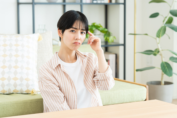 A young Japanese woman in distress in her living room (People)