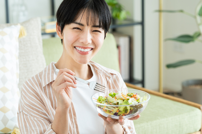 Young Japanese woman eating salad (People)