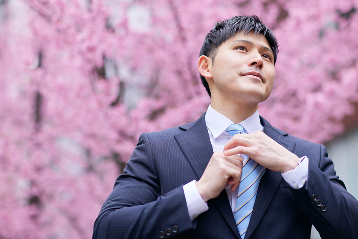 Japanese man re-tightening his tie