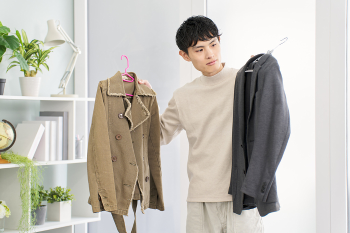 Japanese man arranging clothes (People)