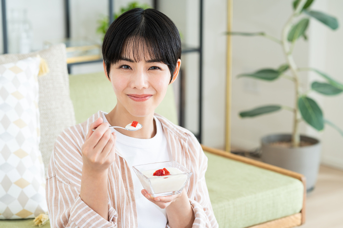 Young Japanese woman eating yogurt (People)
