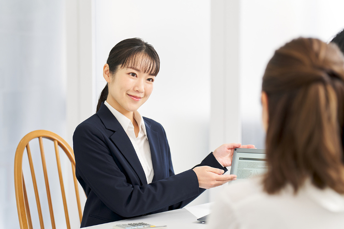 Japanese businesswoman giving information on insurance (Female / People)