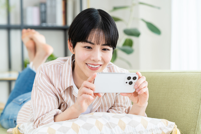 Young Japanese woman watching a video on her phone (People)
