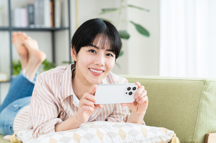 Young Japanese woman watching a video on her phone (People)