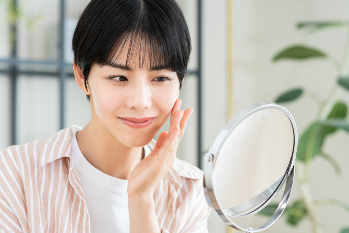 Young Japanese woman looking in the mirror.