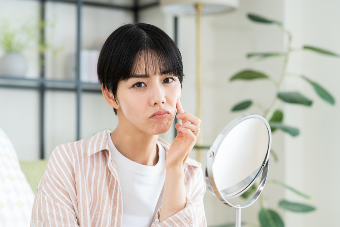 Young Japanese woman suffering from skin problems (People)