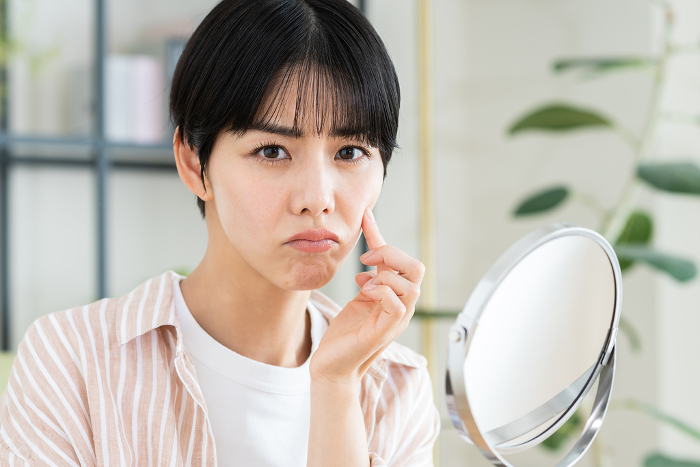 Young Japanese woman suffering from skin problems (People)