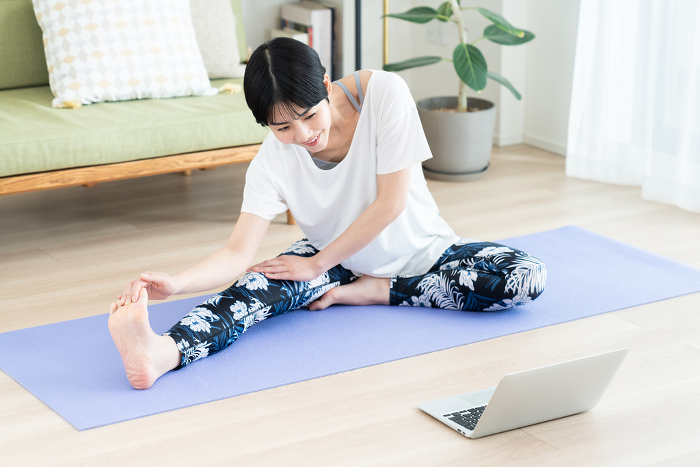 Young Japanese woman practicing yoga at home (People)