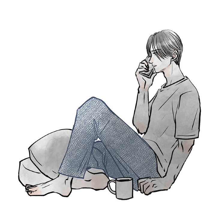 Man sitting on the floor talking on his phone