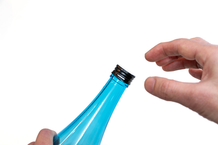Take the cap off the glass bottle.