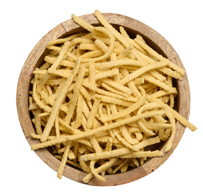 Raw wheat noodles in wooden bowl on isolated background, top view Raw wheat noodles in wooden bowl on isolated background, top view