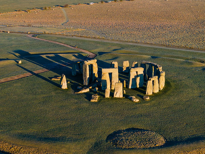Aerial view of Stonehenge site in morning light, Wiltshire, UK Aerial view of the main site at Stonehenge in Wiltshire, UK, bathed in early morning golden light. Stonehenge is one of the most famous prehistoric monuments in the world, it consists of a ring of standing stones, each around 4 metres high, 2.1 metres wide, and weighing around 23 tonnes. The construction of Stonehenge is believed to have started around 3000 BCE. Although it s exact purpose remains a topic of debate, it is thought to have been used as a burial ground, an astronomical observatory, and a site for religious rituals and ceremonies. Today, Stonehenge is a UNESCO World Heritage Site., by LIGHTNING STRIKE MEDIA SCIENCE PHOTO LIBRARY