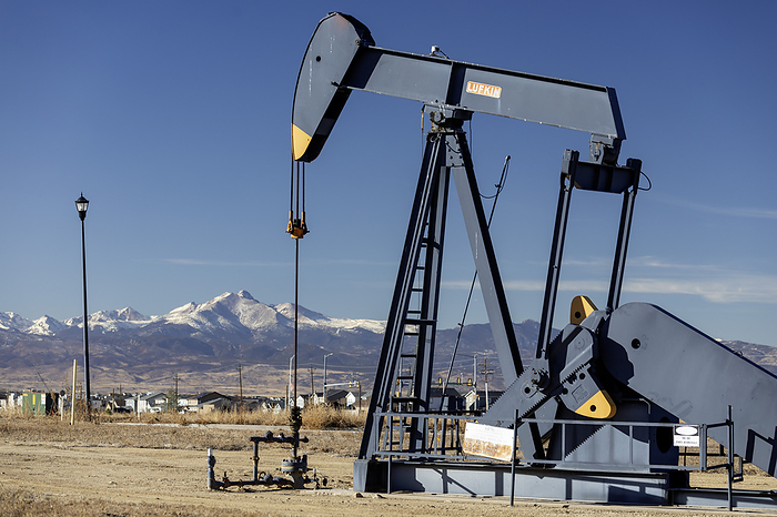 Oil well pumpjack Oil well pumpjack near a housing subdivision with Mount Meeker and Longs Peak in Rocky Mountain National Park in the distance. Photographed in Frederick, Colorado, USA., by JIM WEST SCIENCE PHOTO LIBRARY