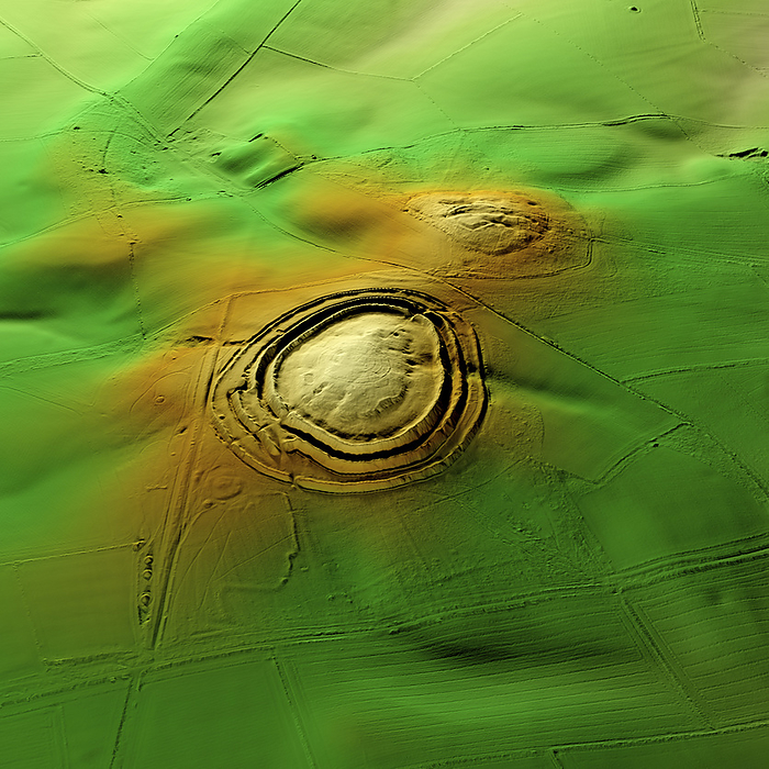 Badbury Rings, UK, 3D LiDAR scan 3D LiDAR scan of Badbury Rings in Dorset, UK. This digital terrain model reveals the site hidden by foliage and the disrupted pattern of the landscape. The hillfort lies within fields but has access via a carpark to the west. Bradbury Rings dates back to the Iron Age, with evidence suggesting that it was constructed around 800 BCE and was occupied until the Roman occupation of Britain. Similar hillforts can be found across the British Isles, which were used for defensive purposes and as centres of community life. Image contains UK public sector information licensed under the Open Government Licence v3.0., by SIMON TERREY SCIENCE PHOTO LIBRARY