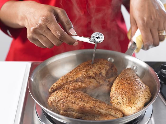 Testing the internal temperature of cooked chicken Food thermometer being used to measure the internal temperature of chicken that is being cooked. The minimum recommended temperature that cooked chicken should reach is 74 degrees Celsius, for at least 30 seconds. This minimises the risk of food poisoning., by US DEPARTMENT OF AGRICULTURE SCIENCE PHOTO  LIBRARY