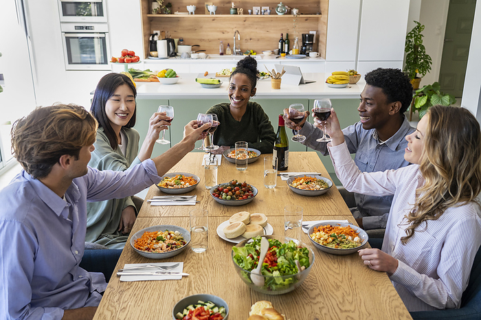 Group of friends toasting with wineglasses during dinner
