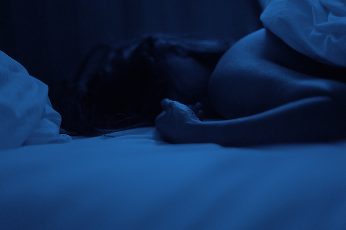 Person sleeping in bed in darkness
