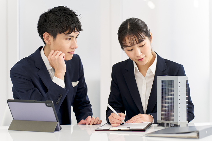 Japanese businesspeople in a meeting about a commercial building (People)
