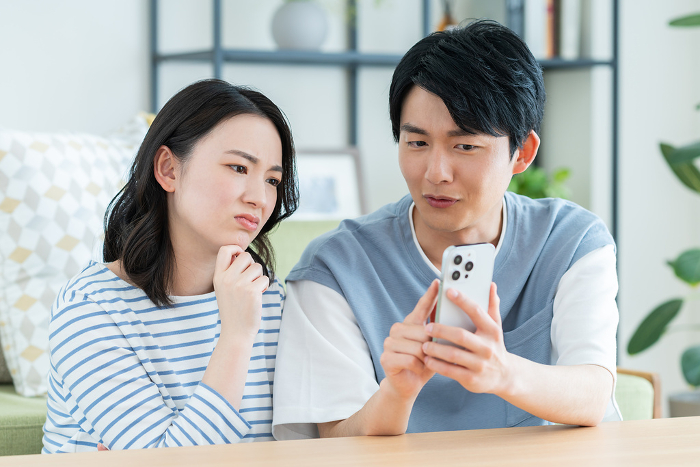 A young Japanese couple having trouble with their cell phone (People)