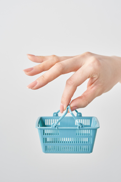 Woman's hand holding a small shopping basket