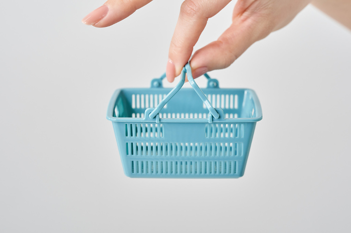 Woman's hand holding a small shopping basket