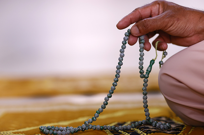 Muslim man praying with islamic prayer beads. Close up on hand. Vietnam. Close up of hand of Muslim man praying with Islamic prayer beads, Chau Doc, Vietnam, Indochina, Southeast Asia, Asia, by Godong