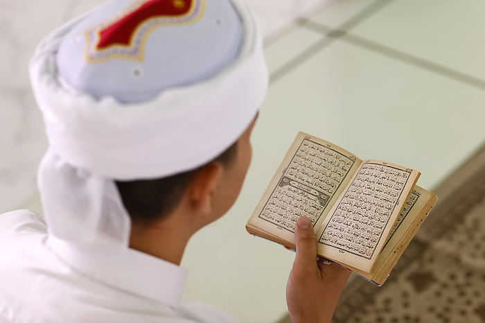 Jamiul Azhar mosque. Muslim man reading an Arabic Holy Quran  Koran . Vietnam. Muslim man reading an Arabic Holy Quran  Koran , Jamiul Azhar Mosque, Vietnam, Indochina, Southeast Asia, Asia, by Godong