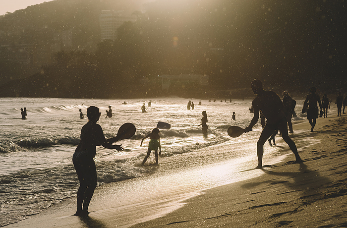 People play racquetball on the beach in Leblon, Rio de Janeiro, Brazil at sunset with a light drizzle People play racquetball on the beach in Leblon, at sunset with a light drizzle, Rio de Janeiro, Brazil, South America, by Alexandre Rotenberg