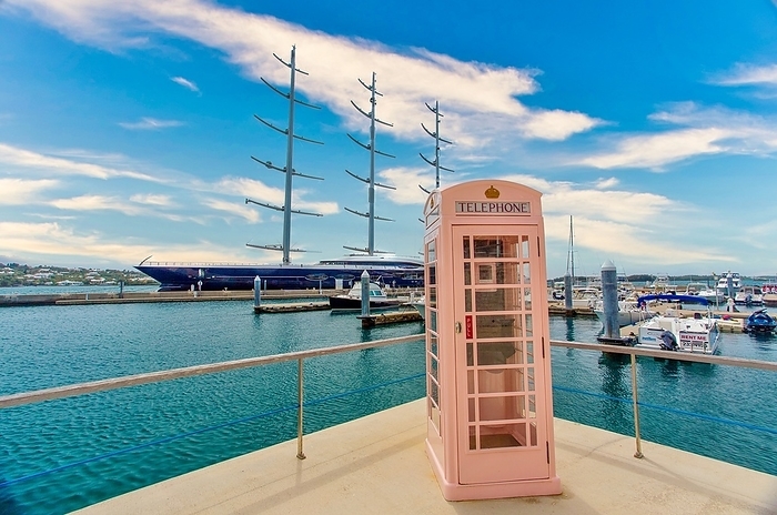 Hamilton Harbour, Bermuda. An old British telephone kiosk with a three masted sailing ship, moored behind. An old British telephone kiosk, with a three masted sailing ship moored behind, Hamilton, Bermuda, North Atlantic, North America, by Barry Davis