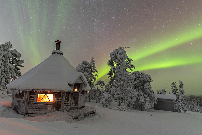 Shades of green color of the northern lights  aurora borealis  above the snowy landscape of the finnish lapland with the typical hut lit by the fire in the foreground, Lapland, Finland, Scandinavia, Europe Shades of green color the Northern Lights  Aurora Borealis  above a snowy landscape with a typical hut lit by a fire inside in the foreground, Finnish Lapland, Finland, Europe, by Paolo Graziosi