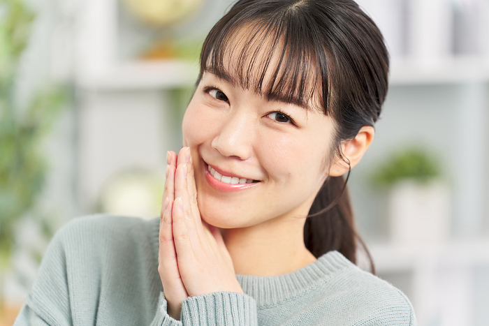 Japanese woman with good teeth talking secretly (People)