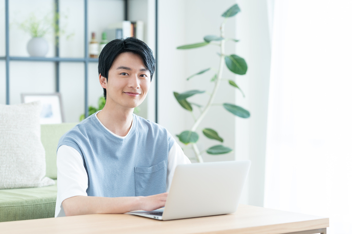 Young Japanese man on computer in living room (People)