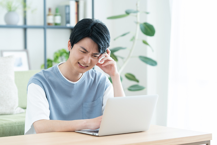 Young Japanese man struggling with his computer (People)