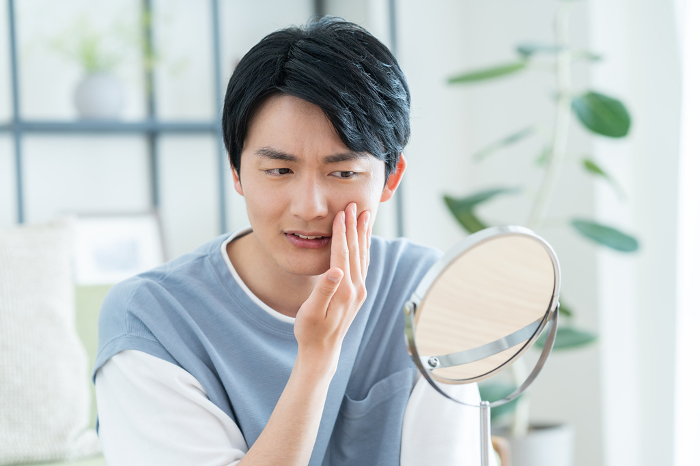 Young Japanese man suffering from skin problems (People)