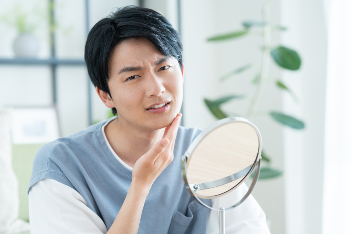 Young Japanese man suffering from skin problems (People)