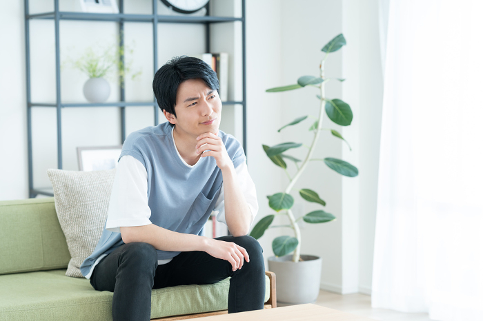 A young Japanese man in distress in his living room (People)