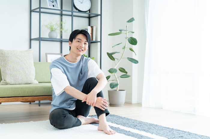 Young Japanese man relaxing in the living room (People)
