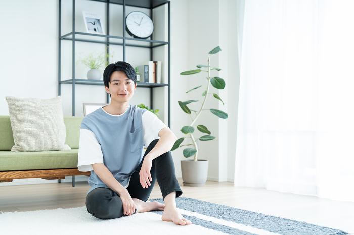 Young Japanese man relaxing in the living room (People)