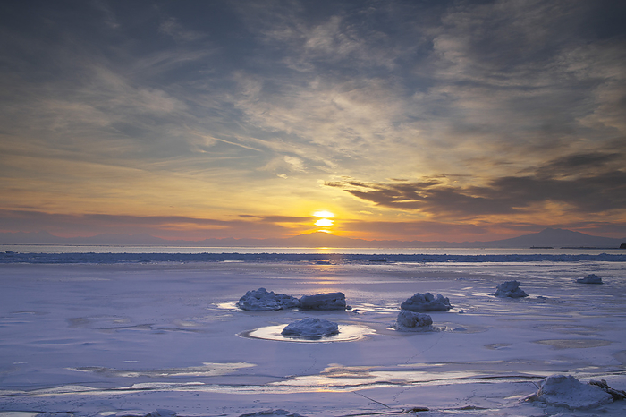 Drift ice on the Sea of Okhotsk and sunrise on Mt. Haibetsu, Hokkaido, Japan