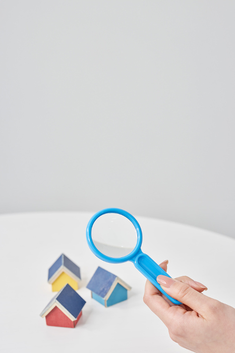 Magnifying glass pointed at a house model