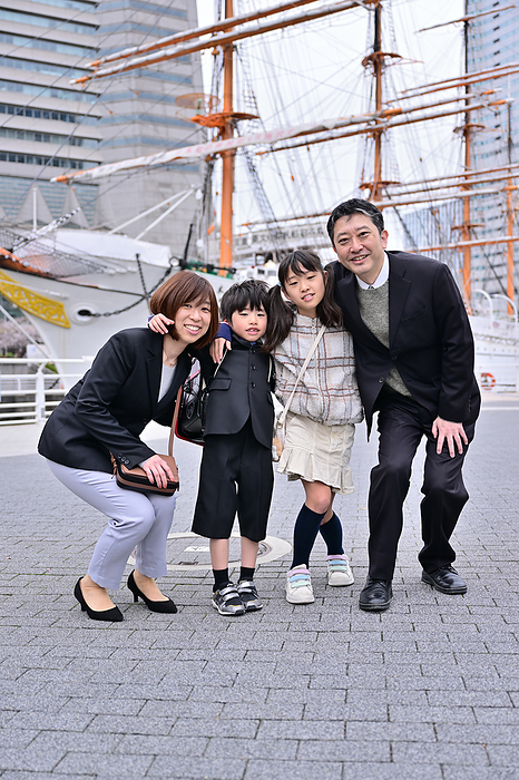 A family poses for a photo in front of the Nippon Maru