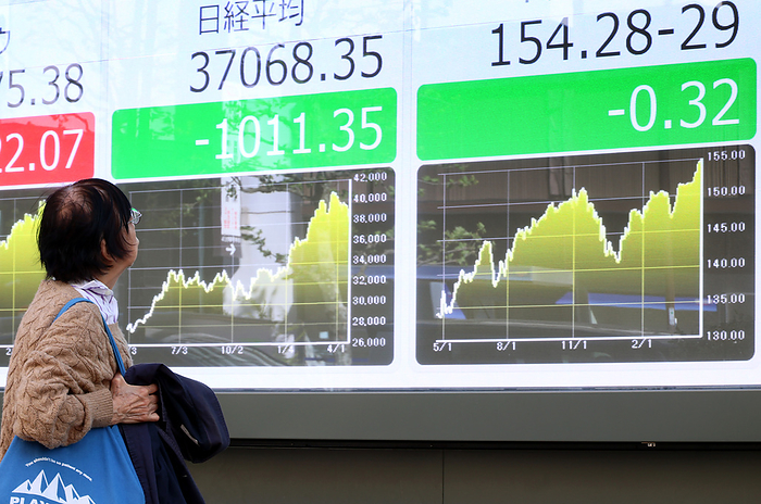 Jaoan s share prices dropped at the Tokyo Stock Exchange April 19, 2024, Tokyo, Japan   A pedestrian watches a share prices board in Tokyo on Friday, April 19, 2024. Japan s share prices dropped 868.1,011.35 yen to close at 37,068.35 yen at the Tokyo Stock Exchange while Japanese yen is traded at 154yen level against US dollar at the forex market.     photo by Yoshio Tsunoda AFLO 